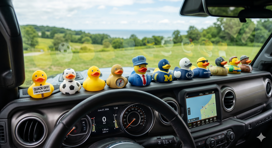 A row of custom 3D printed Jeep ducks with a matte finish on a Wrangler dashboard